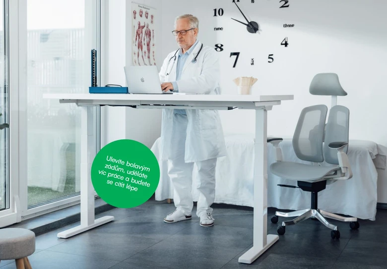 Lékař pracuje na stojacím stole v moderní ordinaci s ergonomickým nábytkem.