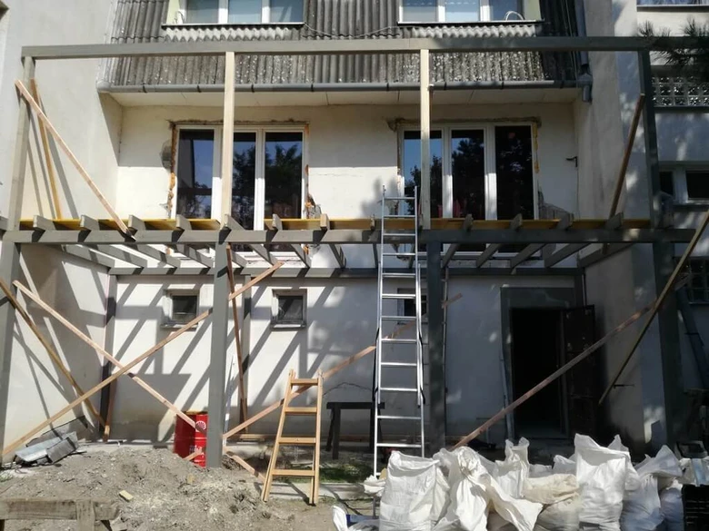 Stavba domu s novými okny na fasádě v procesu rekonstrukce.