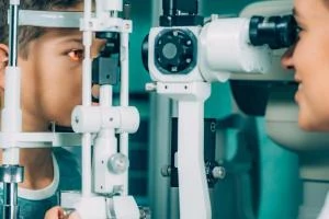Optometrista zkoumá vidění dítěte pomocí speciálního přístroje.