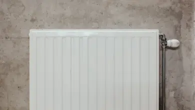 Bílý radiátor na zdi v interiéru bez krytu.