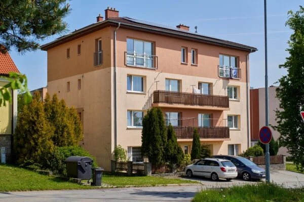 Bytový dům s novými okny a balkony na české ulici.
