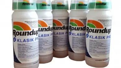 Pět lahví herbicidu Roundup Klasik na bílém pozadí.