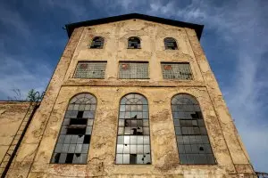 Starý průmyslový dům s velkými okny na modré obloze